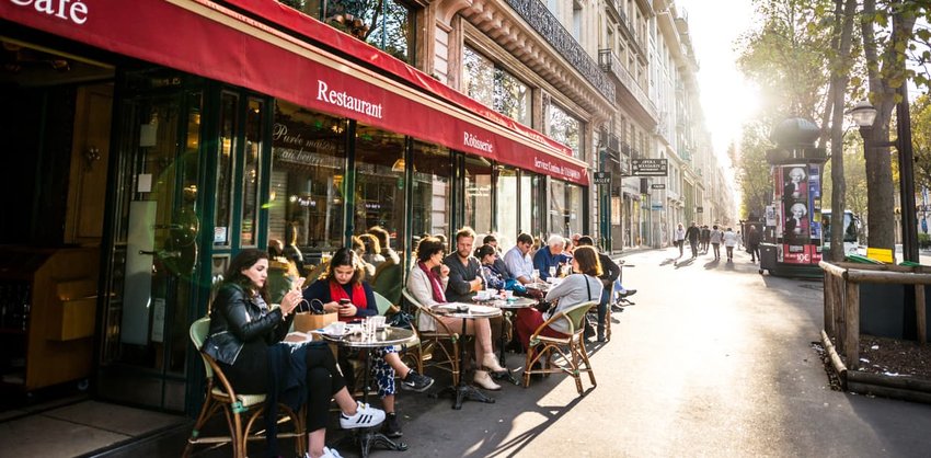 People relaxing, eating and drinking in restaurant in Paris, France