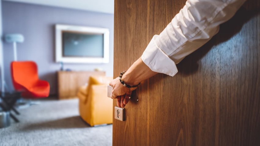 Man hand opening the door of the luxurious hotel room