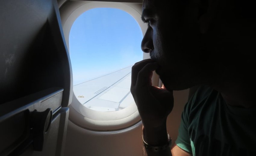 person on plane looking out window