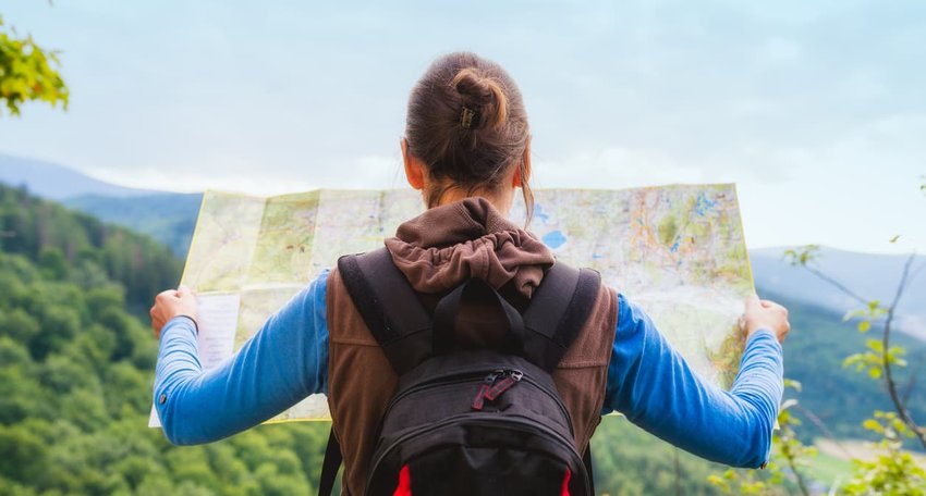 hiker looking at map on ridge