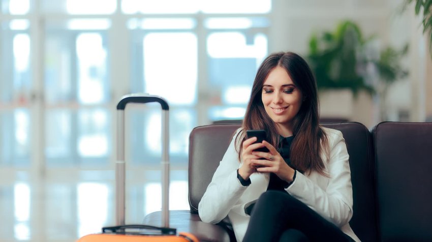 woman reading phone in lobby