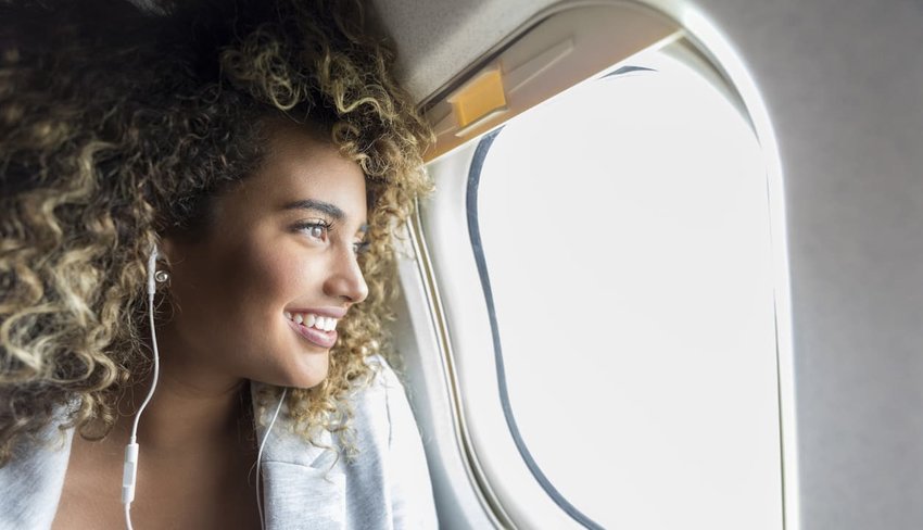 Woman looking through window on airplane