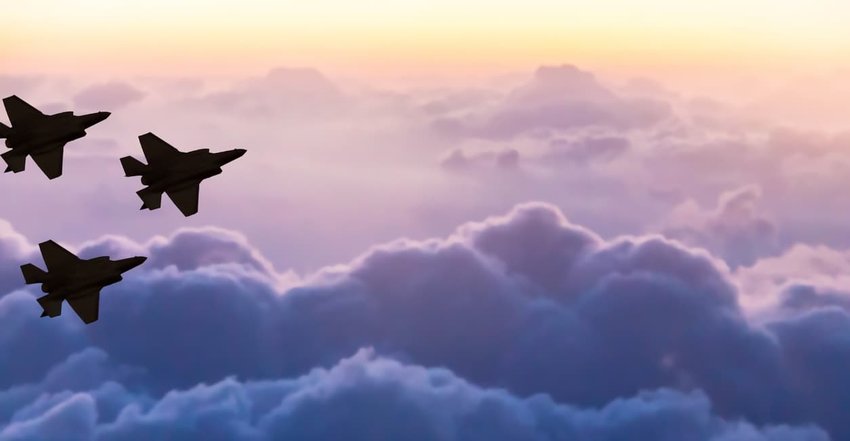 Silhouettes of three F-35 aircraft on sunset sky background