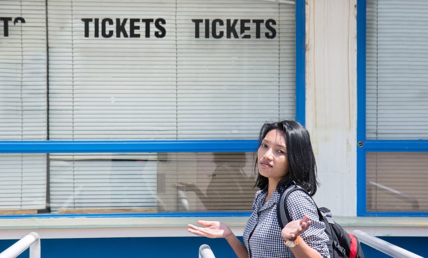 Disappointed woman stands before the closed ticket office