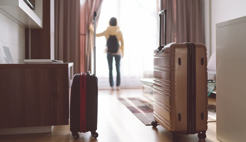 woman with luggage in hotel room