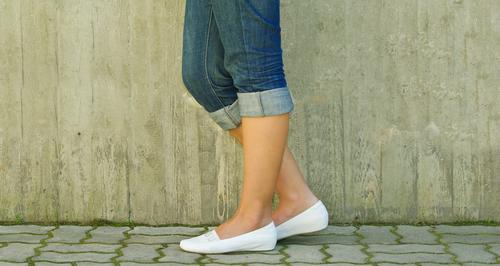 Woman standing with her leg tilted 