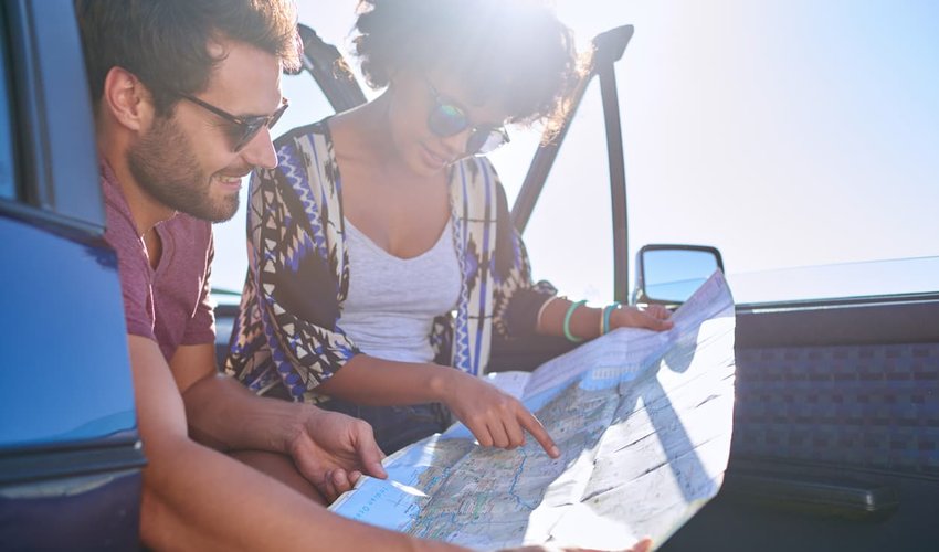 Young lovely couple using map during roadtrip