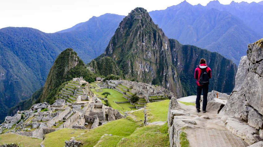 Woman overlooking the Inca ruins of Machu Picchu