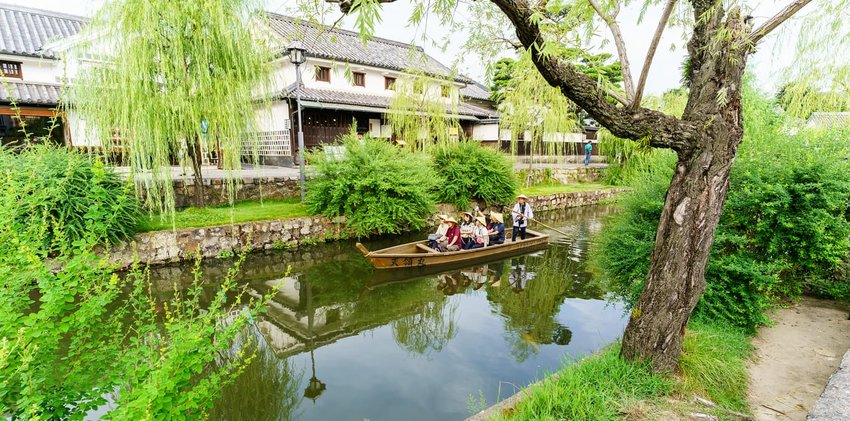 Tourists are enjoying with the old-fashioned boat along the Kurashiki canal in Kurashiki city.