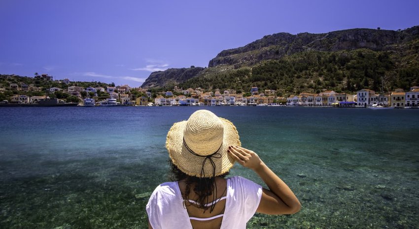 woman looking at Greek Islands across the water