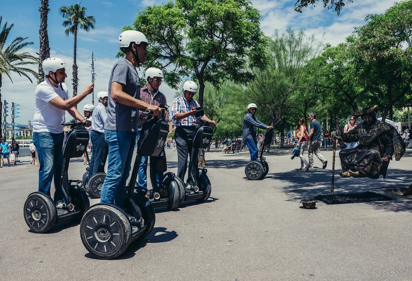 Segway trip participants looks at street performer