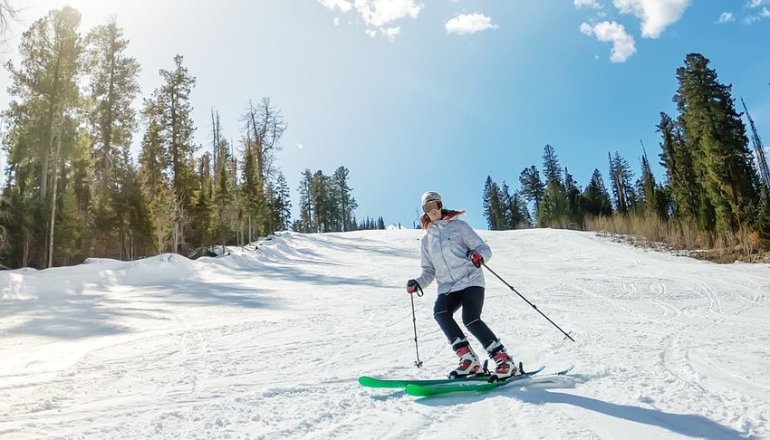 Young girl on alpine skiing on a snowy track against the sky