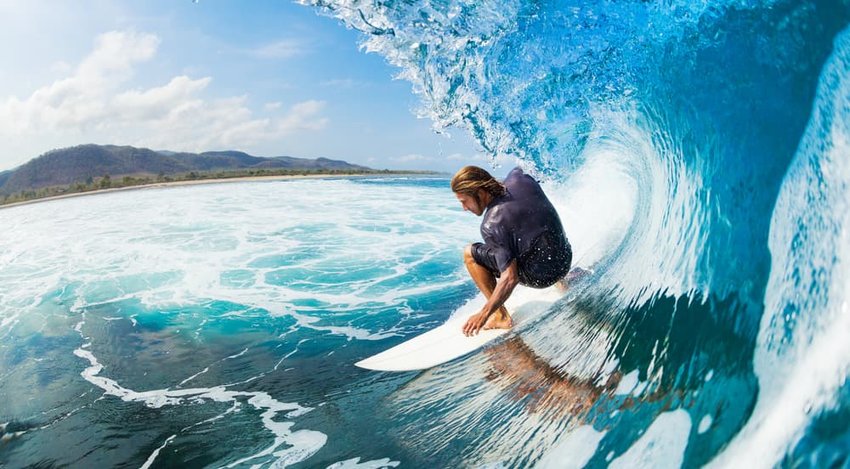 Surfer on Blue Ocean Wave in the Tube Getting Barreled