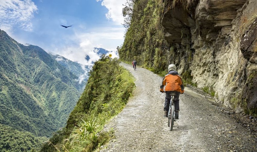 Bike tourists ride on the "road of death" downhill track in Bolivia.