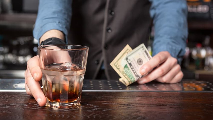 Barkeep giving whiskey glass with booze