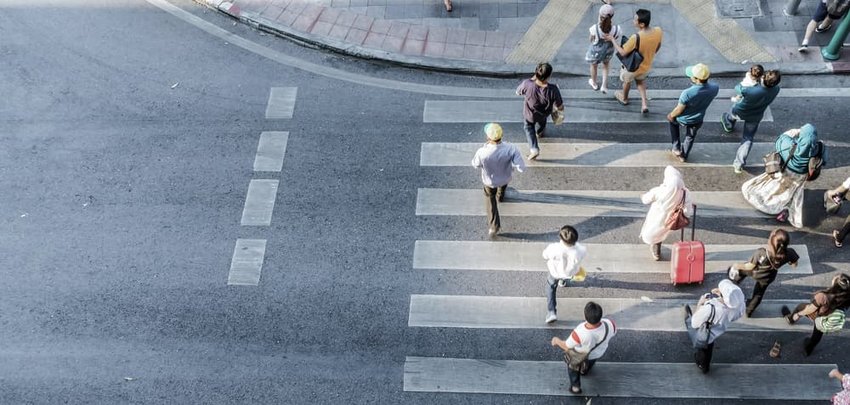 Blur people are moving across the pedestrian crosswalk in the city road