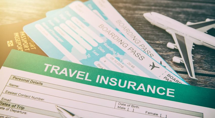 Booking travel insurance with model plane on wooden background