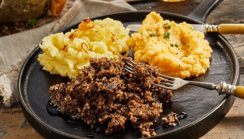 Rustic serving of haggis, neeps and tatties on a metal skillet