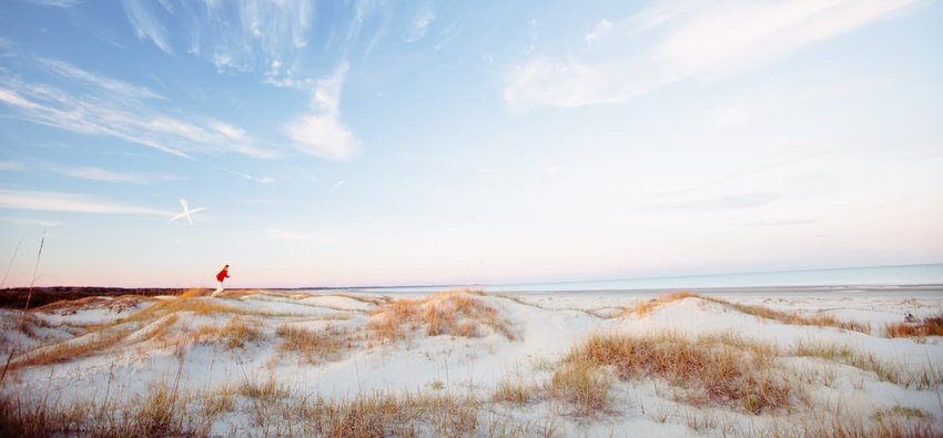 Young healthy man running on the beach at sunset