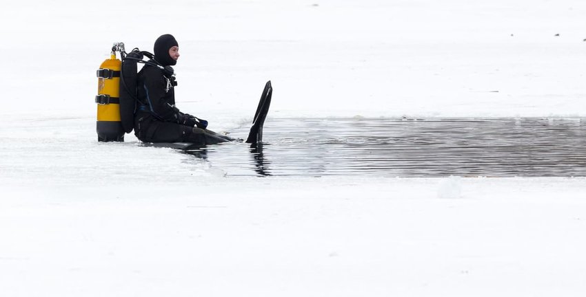 under ice diver waiting to submerge in water