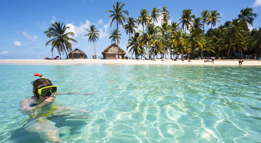 Woman enjoying swiming with scuba mask near Isla de Perro island in Caribbean See