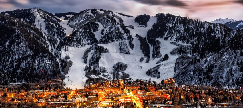 Aspen at night backed by snow covered mountains