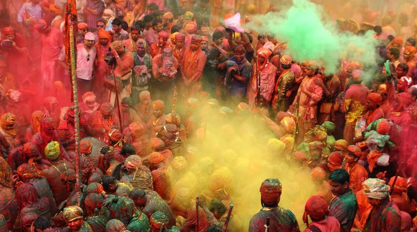 People throw colors to each other during the Holi celebration at Krishna temple