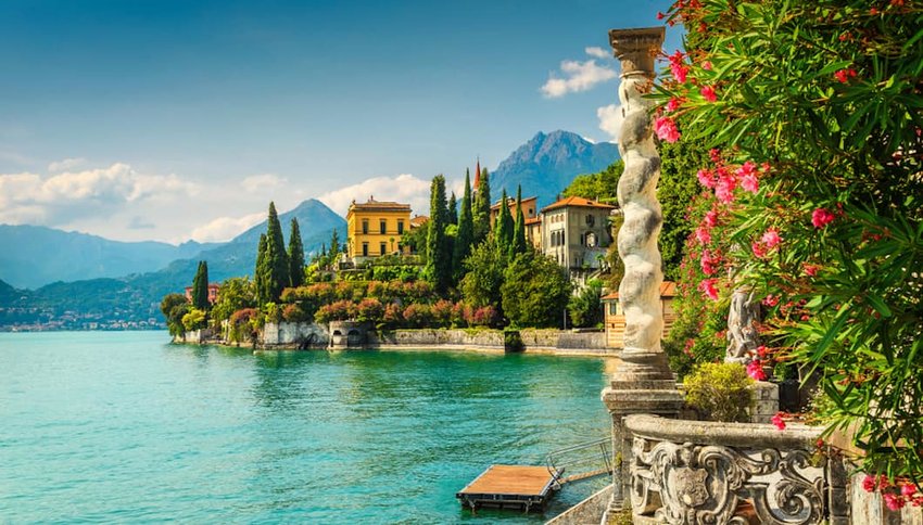 Photo of Lake Como shoreline with mountains in the distance