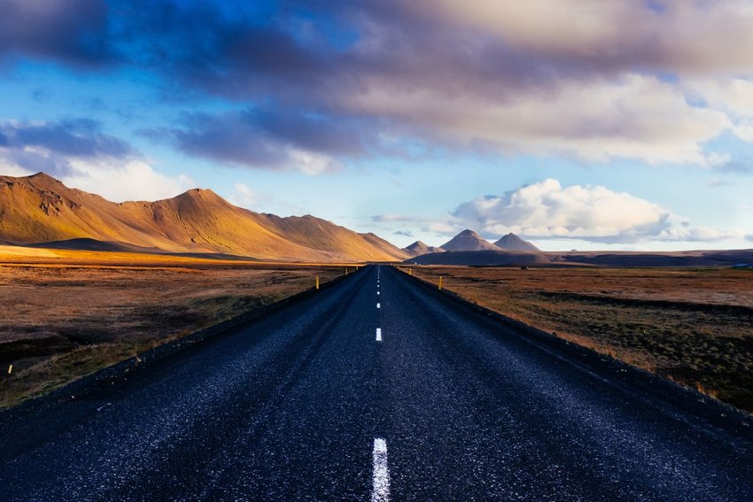 Empty Icelandic road leading to mountains