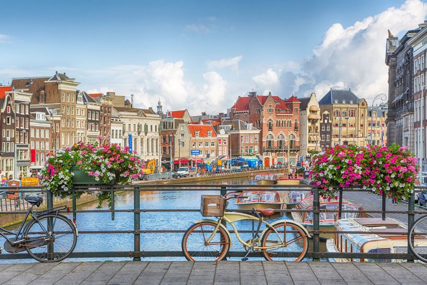 Photo taken on a bridge in Amsterdam, with bikes in the foreground and buildings in the background