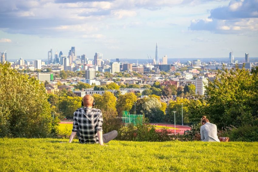 Tourists looking over London city skyline from Parliament Hill in Hampstead