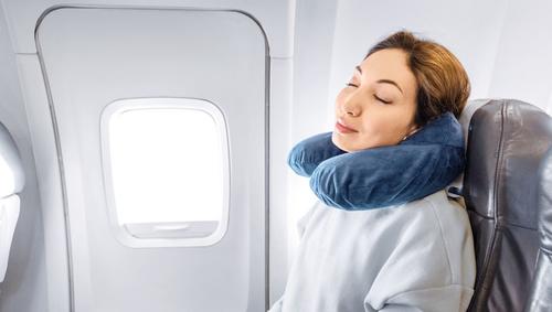 girl sleeping on the plane with a pillow