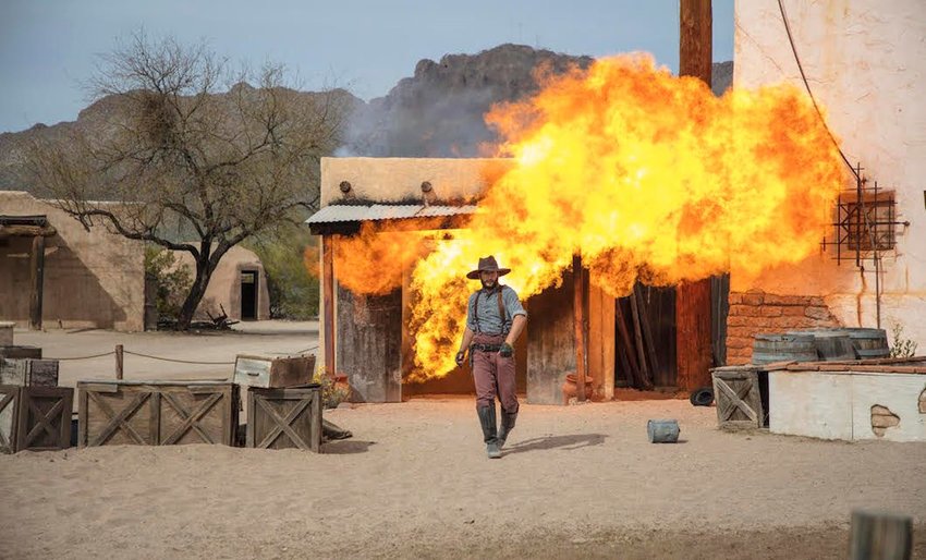 Photo of cowboy walking away from an explosion
