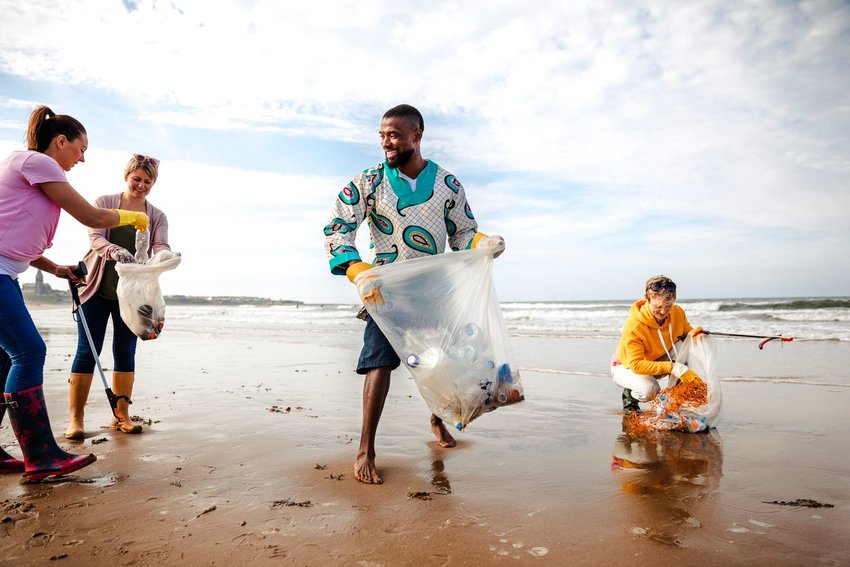 Group of people picking up trash on a beach