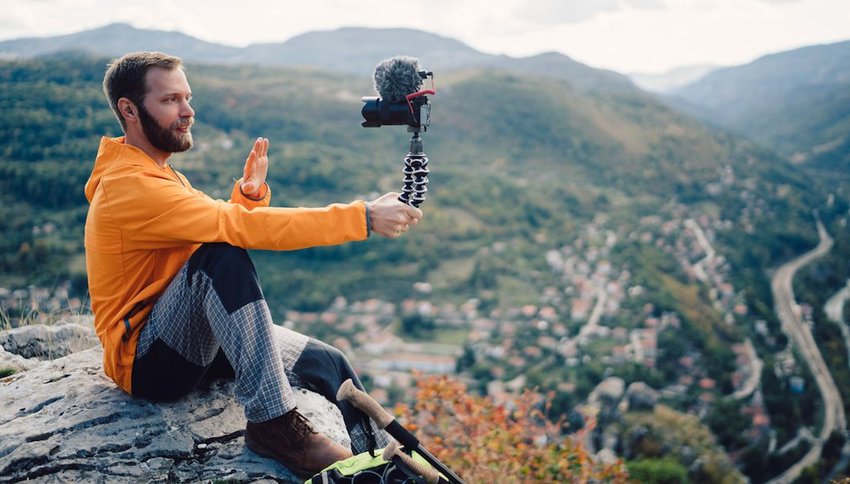 tourist hiking and vlogging on the mountain top
