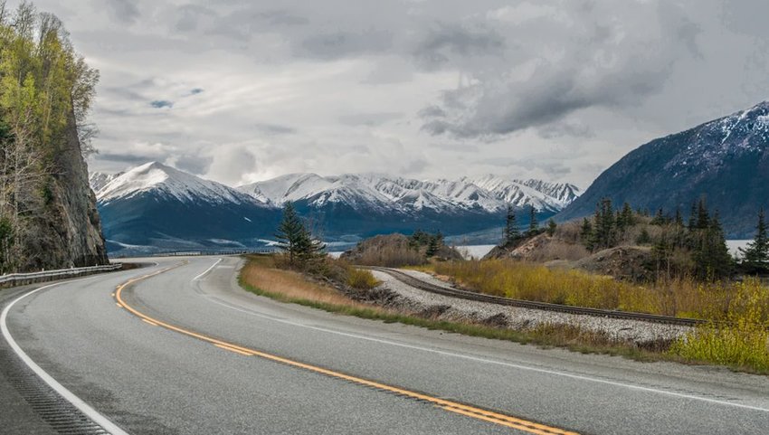 Seward Highway curving by snow-covered mountains outside Anchorage