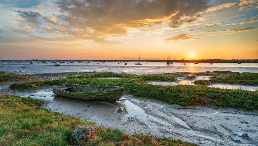 old boat in the salt marsh at West Mersea at sunset