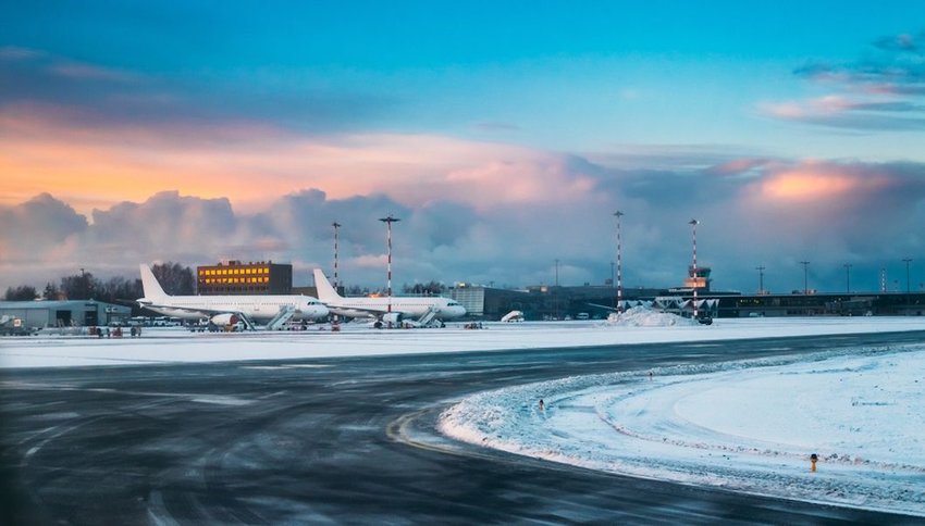 Aircraft stand on ground at International Airport terminal in snow