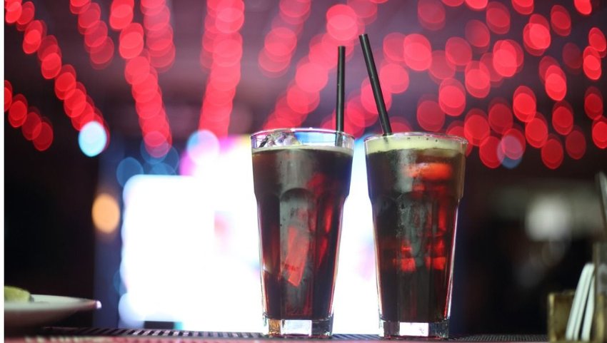 Front view of Fernet cocktails on a bar with red lights in background