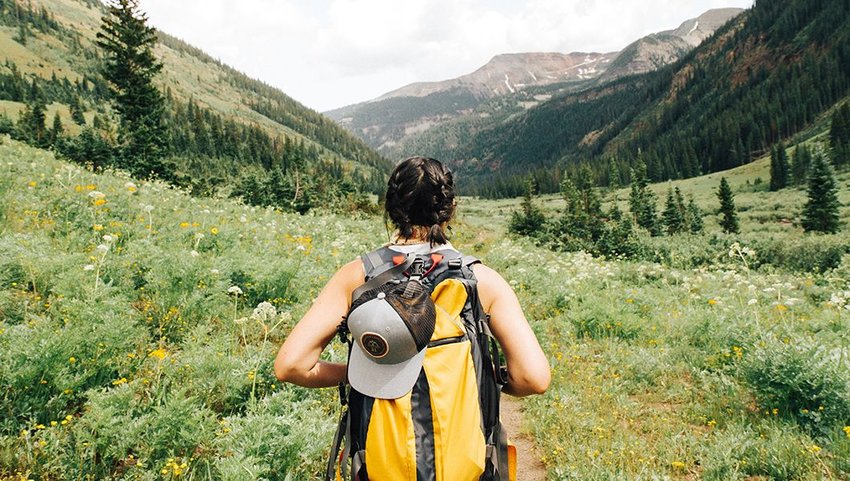 Woman hiking in valley with mountains in background