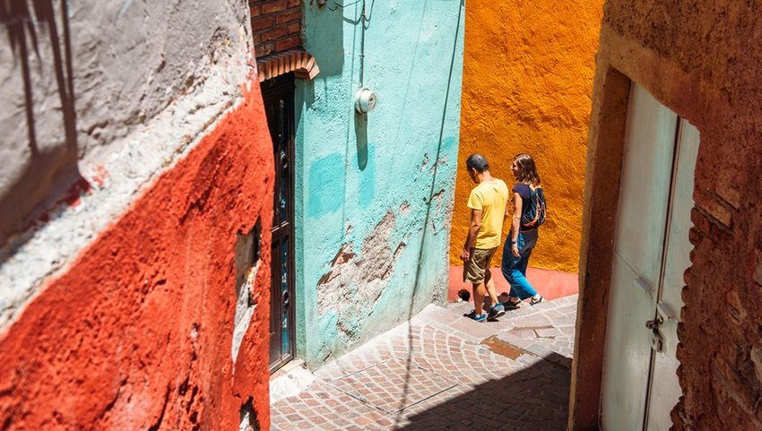 Two people walking through a city