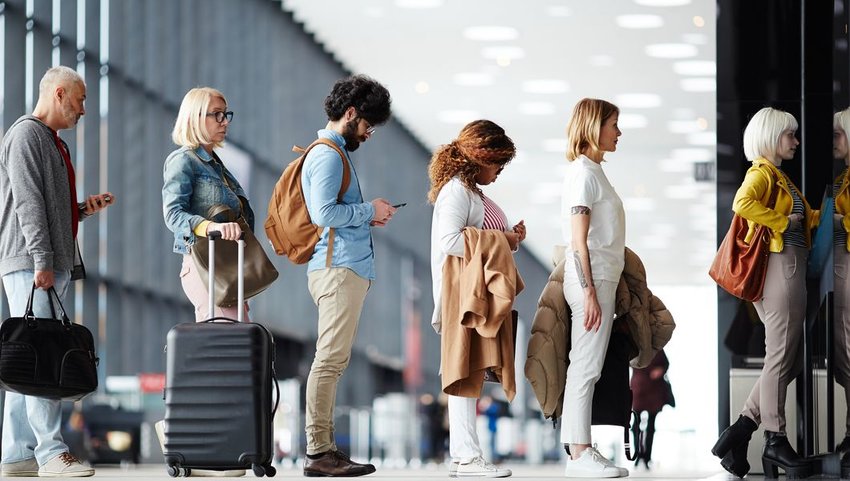 Side view of travelers waiting in line at airport security