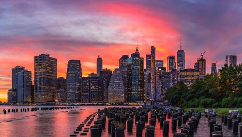 Red sky sunset over New York City skyline from Brooklyn Bridge Park