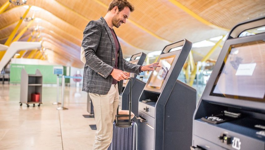 Male traveler using self check-in machine at the Madrid–Barajas Airport
