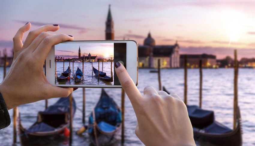 tourist hands taking photo of Venice canal