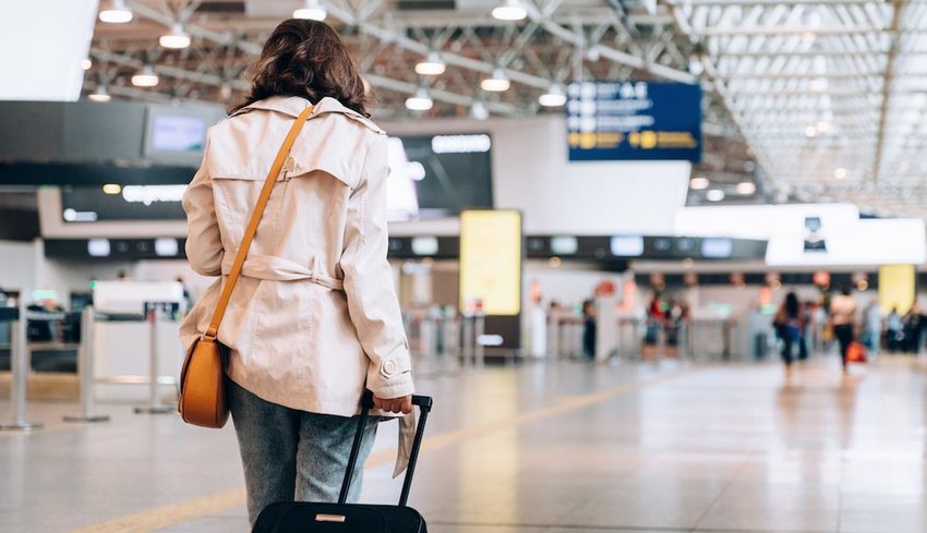 woman in a coat walking through airport