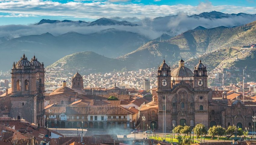 Morning sun rising at Plaza de armas with Adean Moutain in background, Cusco, Peru