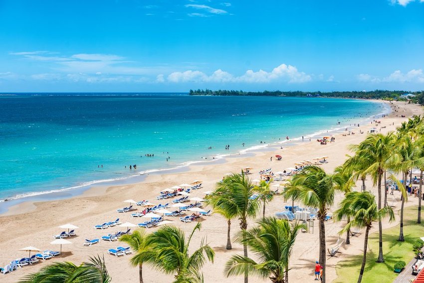 Lounge chairs on a long beach in San Juan