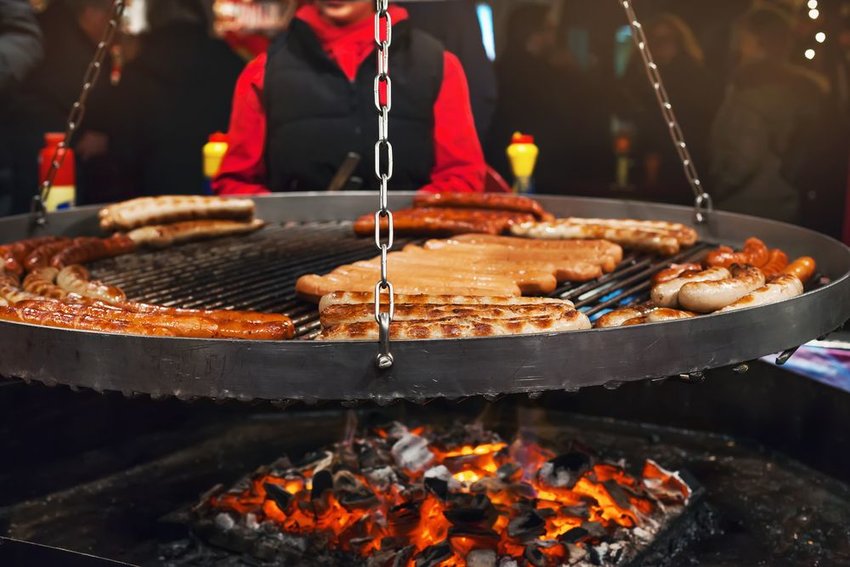 Wurst being cooked on a swinging grill 