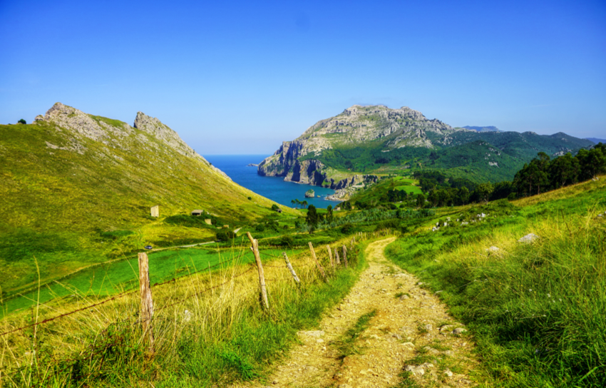 Road of Camino de Santiago towards the ocean and hilly landscape